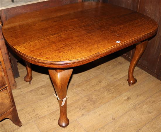 A 1920s golden oak oval topped dining table, W.130cm